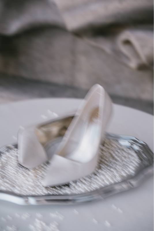 Editorial close-up of luxury wedding heels on a pearl tray, photographed at Palais de Tokyo in Paris.