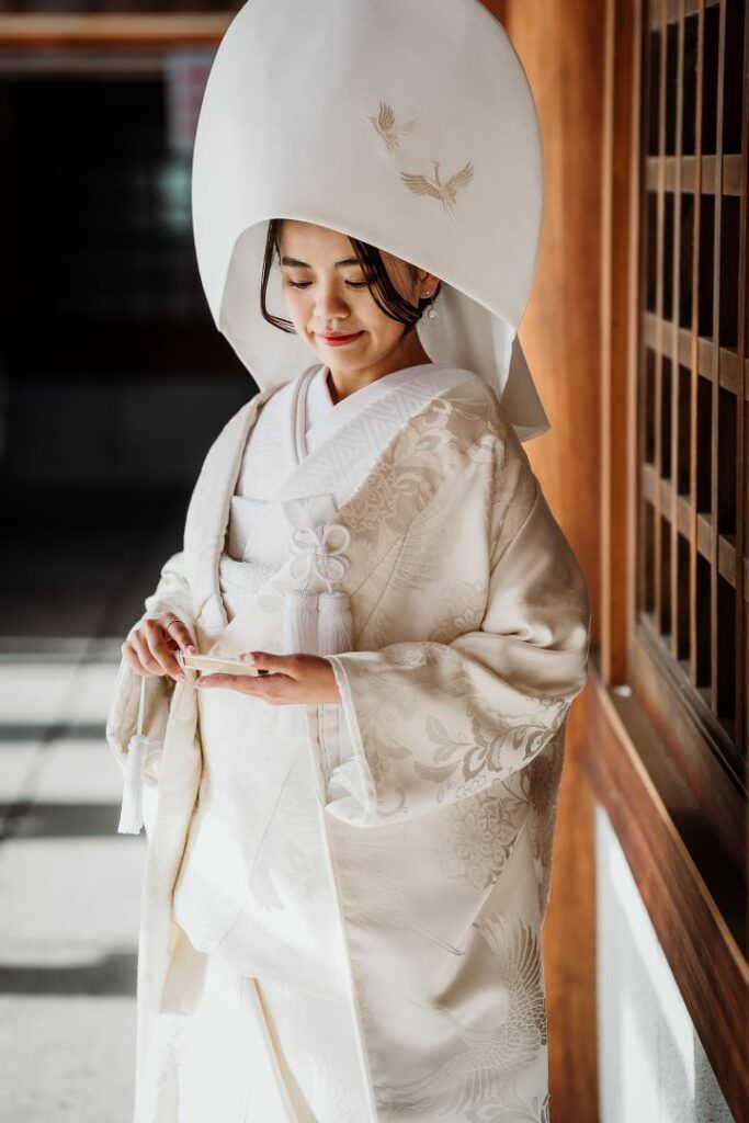 Elegant bride during a refined winter wedding in Hokkaido, standing in soft natural light in traditional attire.