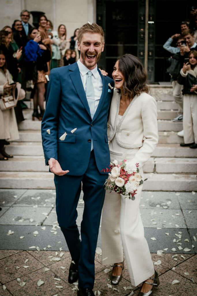 Elegant couple leaving a parisian city hall after their wedding ceremony.