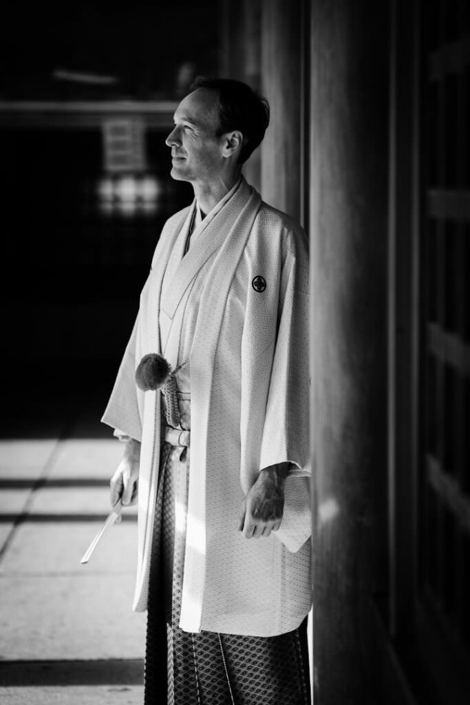 Editorial black-and-white portrait of the groom in traditional Japanese wedding attire in Hokkaido.