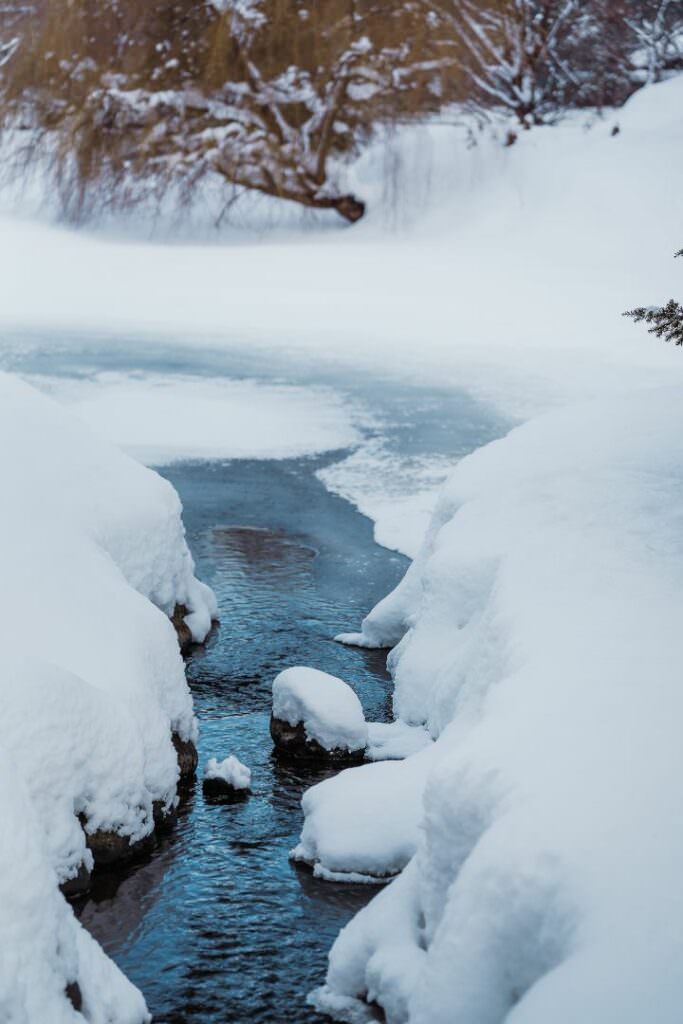 Frozen river surrounded by deep snow in Hokkaido, photographed during a refined winter destination wedding.