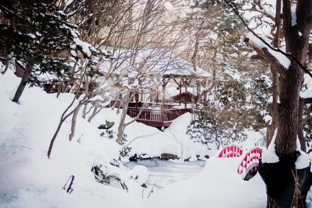 Snow-covered Japanese garden in Hokkaido, captured during an elegant winter destination wedding.