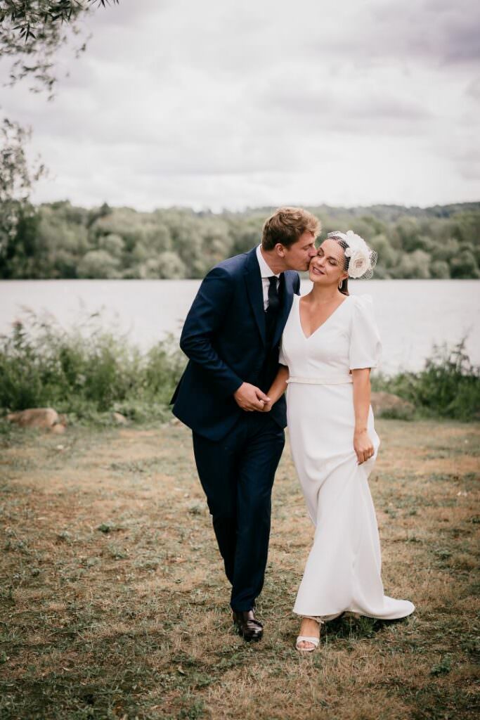 Intimate wedding couple walking by the lake in France, sharing a tender and elegant moment.