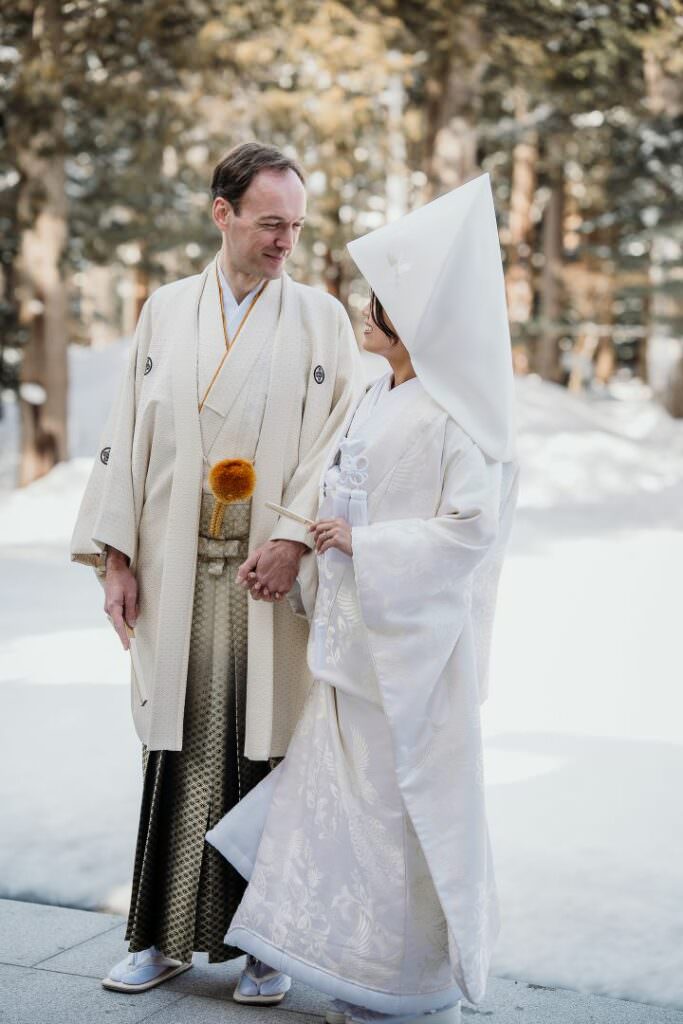 Elegant couple during their luxury winter destination wedding in snowy Hokkaido, Japan.