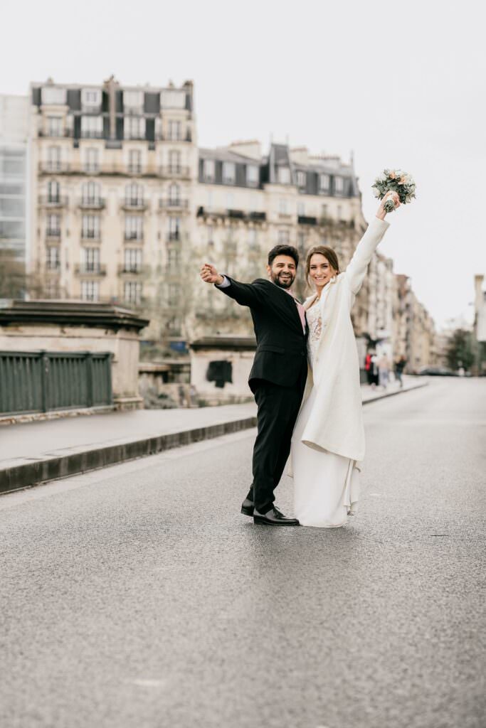 Editorial Paris wedding portrait of a joyful couple celebrating on an empty street.