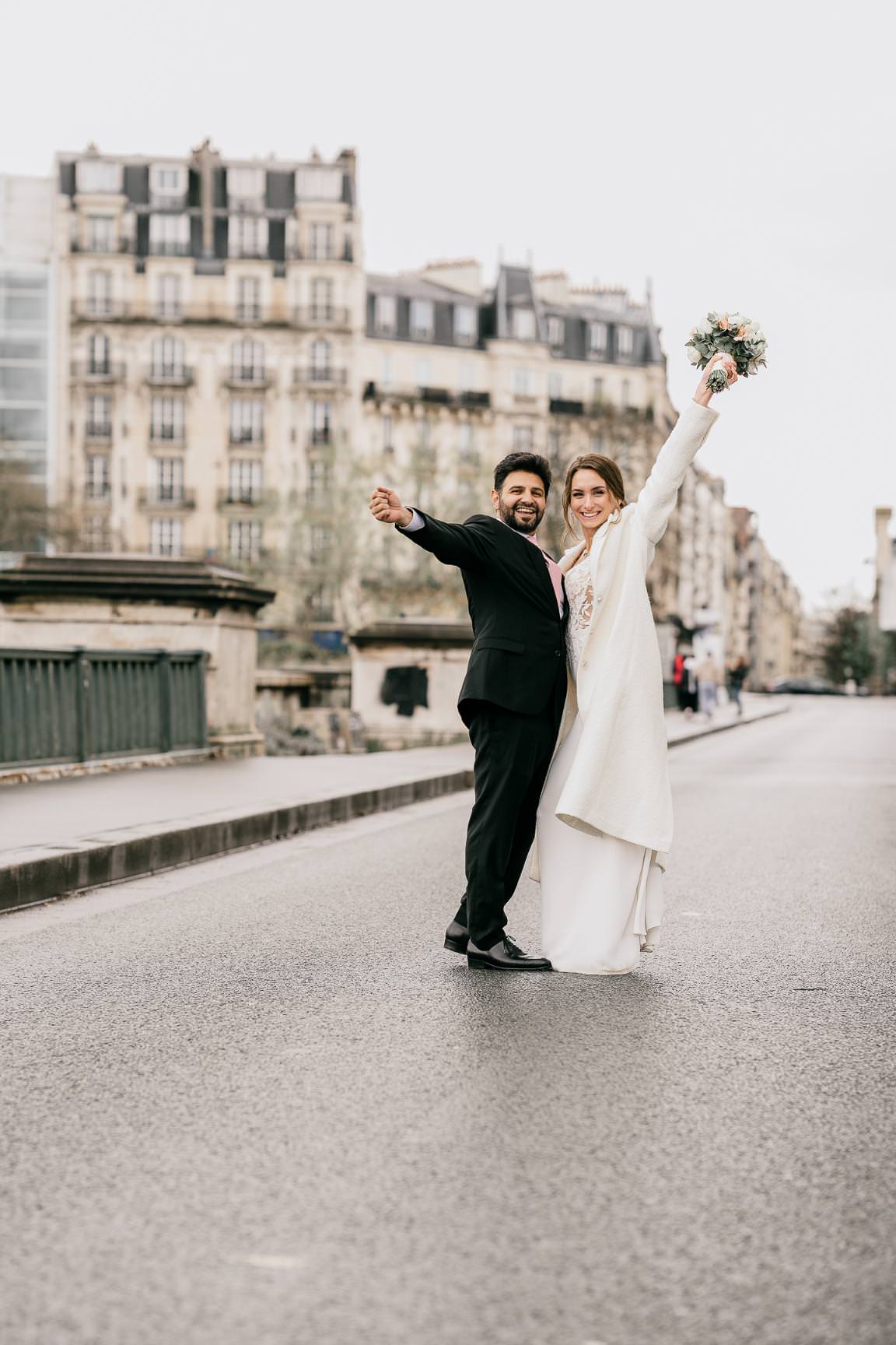 Editorial Paris wedding portrait of a joyful couple celebrating on an empty street.