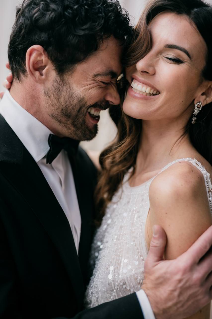 Elegant portrait of a couple sharing a joyful moment on their wedding day.