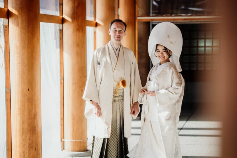 Elegant international couple during their refined Japanese wedding ceremony in Hokkaido, standing gracefully in natural light at the shrine.