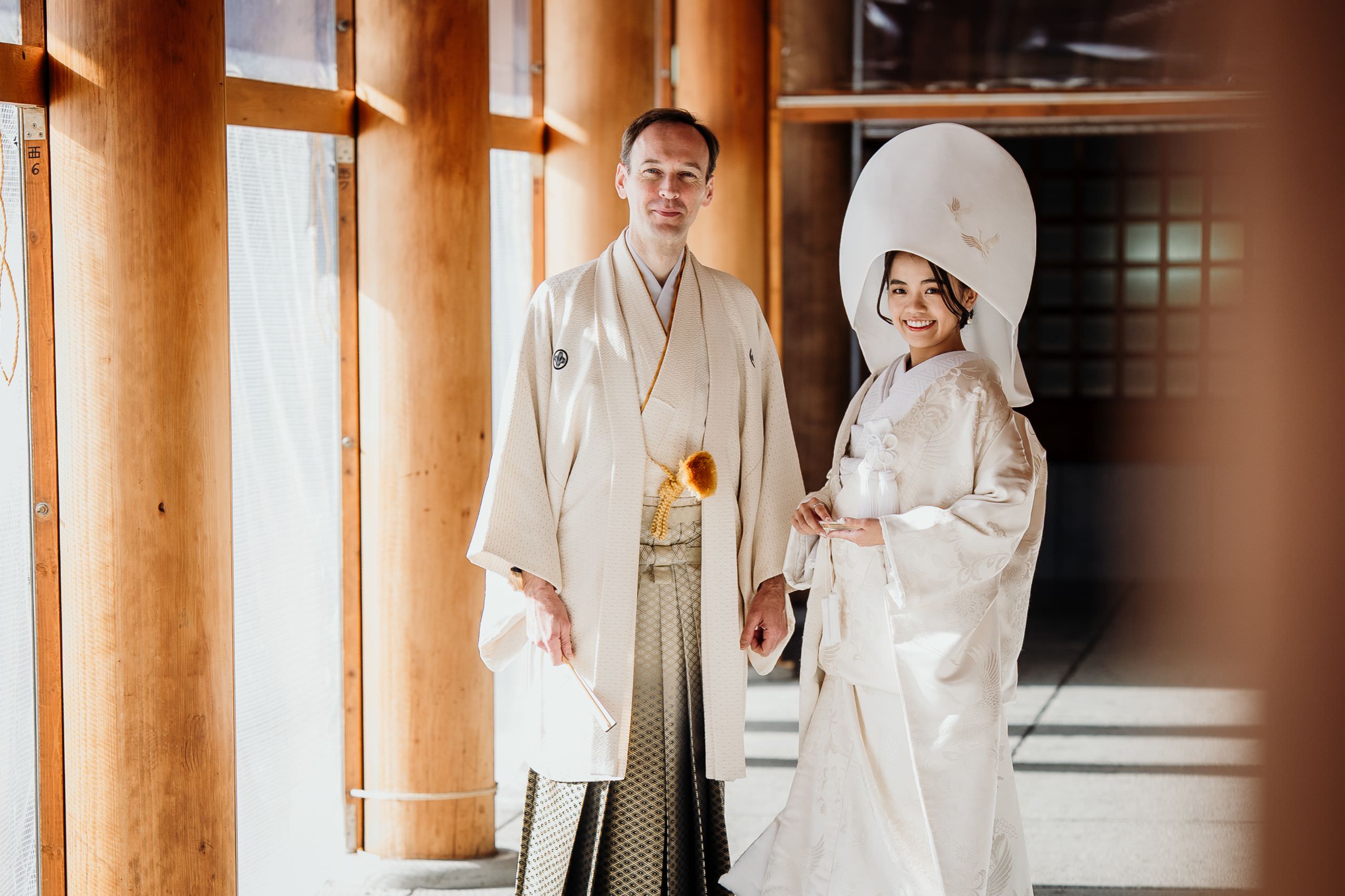 Elegant international couple during their refined Japanese wedding ceremony in Hokkaido, standing gracefully in natural light at the shrine.