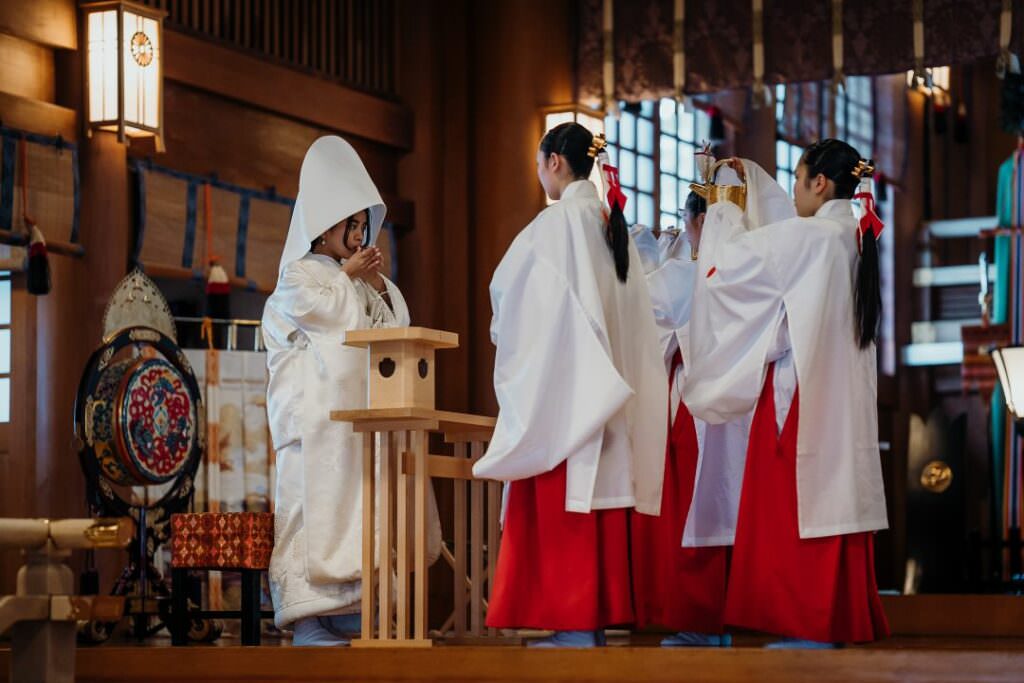 Japanese bride surrounded by miko priestesses during a refined Shinto wedding ceremony in Hokkaido.