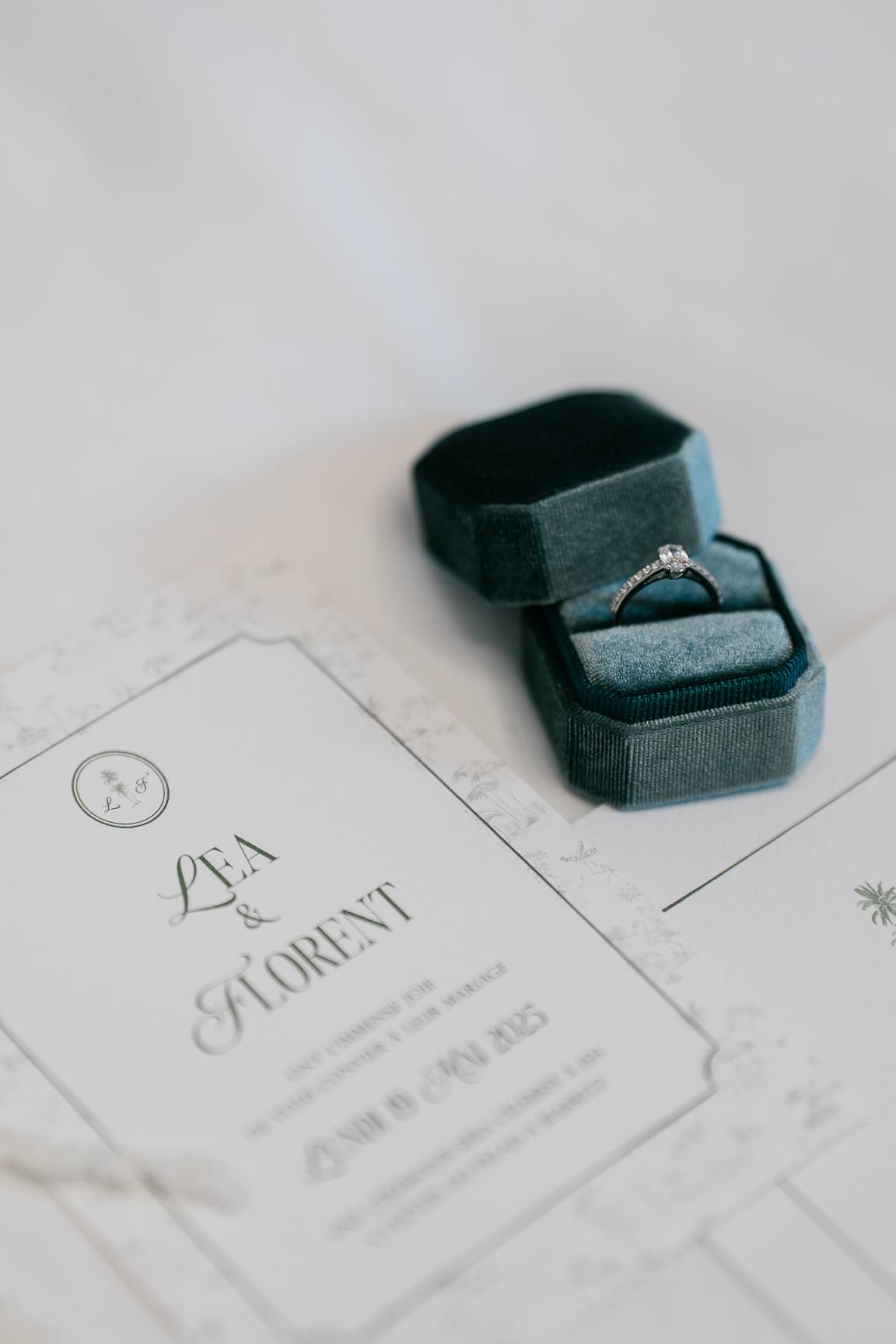 Elegant flatlay of wedding rings and stationery with refined Parisian styling.
