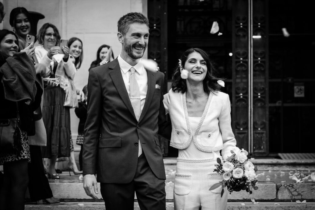 Black and white photo of a joyful city hall wedding exit near Paris