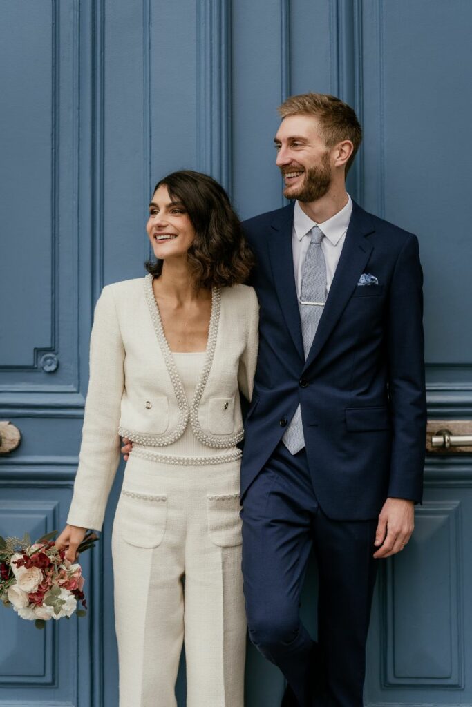 Bride and groom posing in front of a blue Parisian door