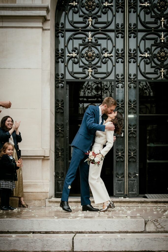 Bride and groom kissing in front of Neuilly-sur-Seine city hall after their ceremony