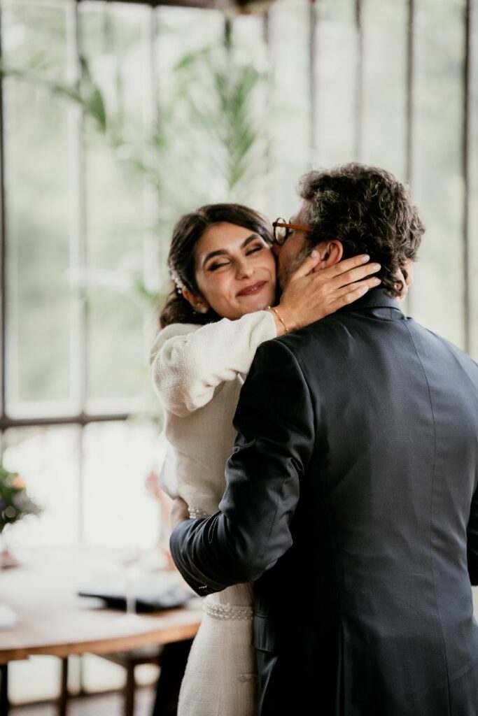 Emotional father and daughter embrace during an intimate wedding celebration
