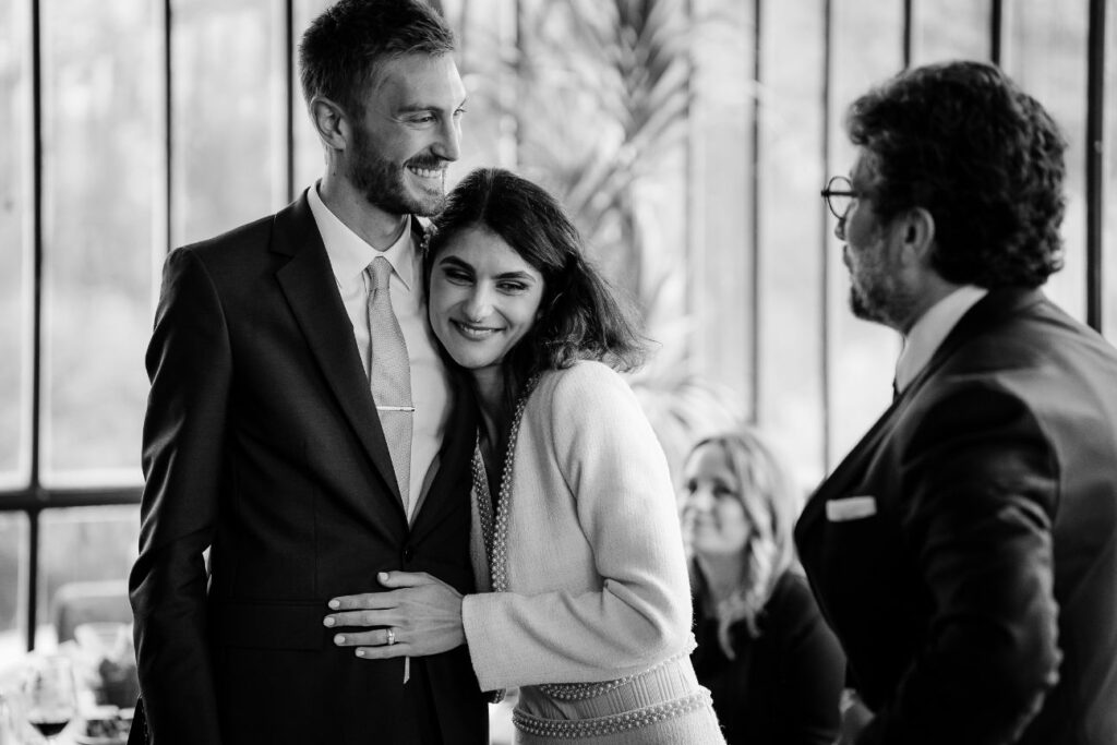 Black and white photo of an intimate wedding moment during a speech, filled with emotion