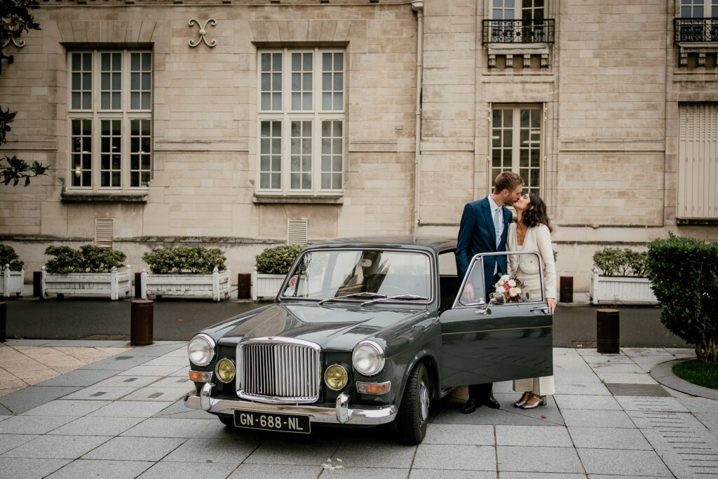 Bride and groom beside a vintage car after their city hall wedding near Paris